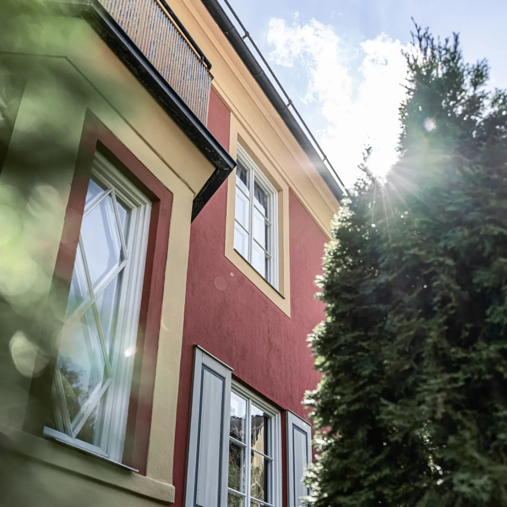 puts-fasadteknik-rott-hus-med-vita-fonster-underifran